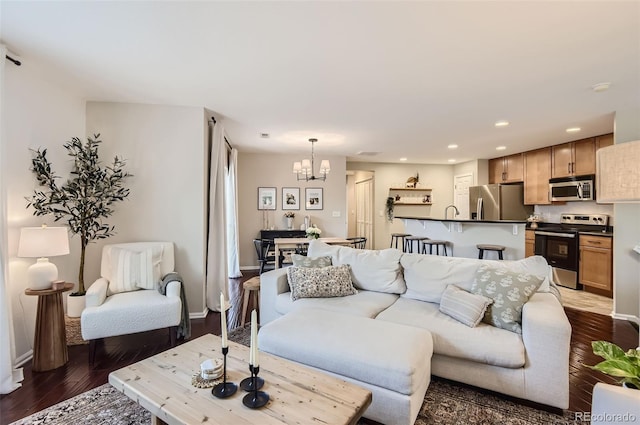 living room with dark hardwood / wood-style floors and an inviting chandelier