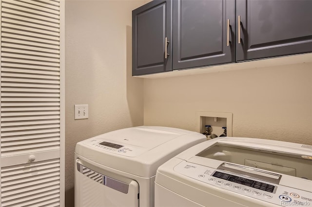 laundry room featuring washer and dryer and cabinets