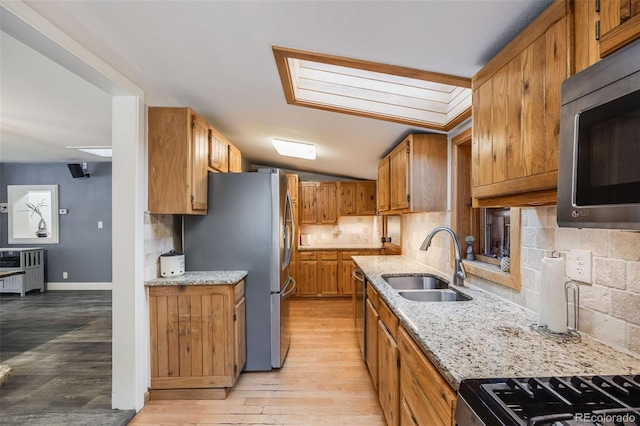 11531 S Deer Creek Rd, Littleton, CO 80127 - kitchen with appliances with stainless steel finishes, radiator, backsplash, and brown cabinetry