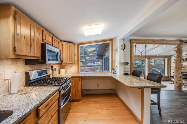 11531 S Deer Creek Rd, Littleton, CO 80127 - kitchen featuring stainless steel appliances, a breakfast bar, light wood-style floors, and tasteful backsplash