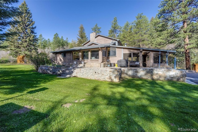 11531 S Deer Creek Rd, Littleton, CO 80127 - rear view of house featuring a chimney, a patio area, and a yard
