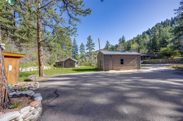 11531 S Deer Creek Rd, Littleton, CO 80127 - view of side of property with an outbuilding and asphalt driveway