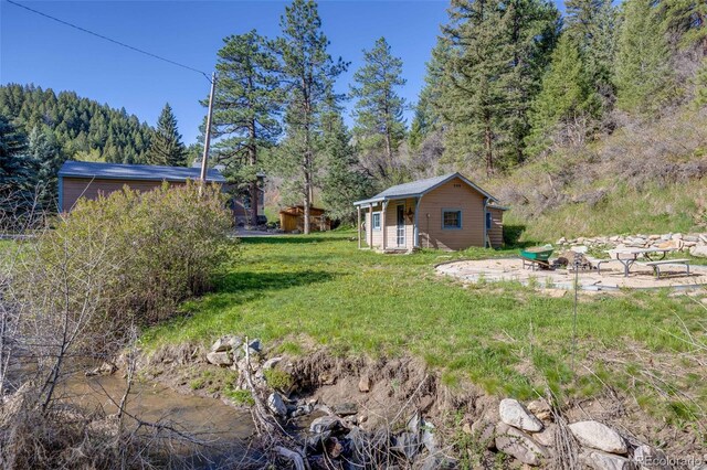 11531 S Deer Creek Rd, Littleton, CO 80127 - view of grassy yard featuring an outdoor structure and a wooded view