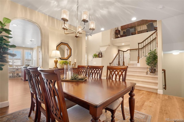 dining space with light wood-type flooring and an inviting chandelier