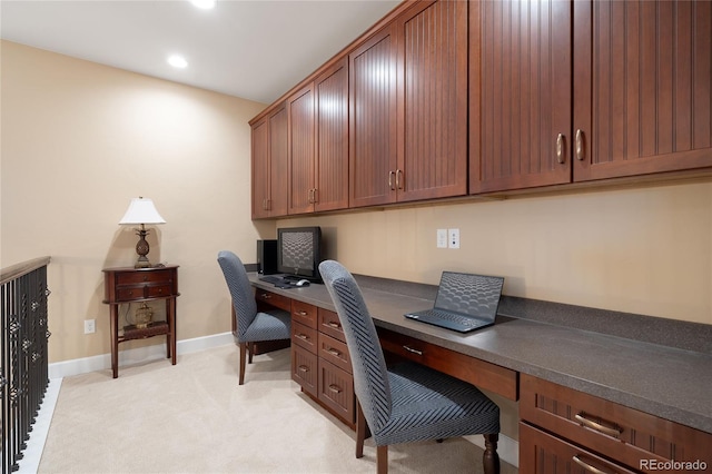 carpeted office space featuring built in desk