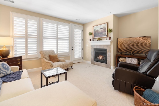 living room featuring a tiled fireplace and light colored carpet