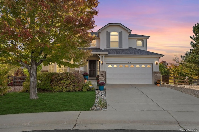 view of front of home featuring stucco siding, concrete driveway, an attached garage, fence, and a front lawn