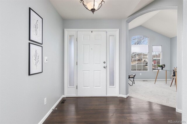 entryway with arched walkways, baseboards, and wood finished floors