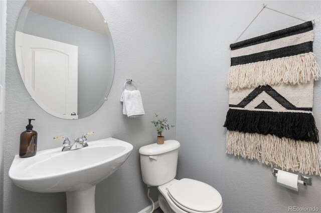 half bath featuring a sink and toilet