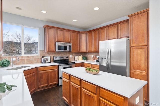 kitchen featuring a sink, light countertops, appliances with stainless steel finishes, tasteful backsplash, and dark wood finished floors