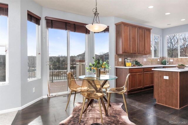 kitchen with tasteful backsplash, a wealth of natural light, light countertops, and dark wood-style floors