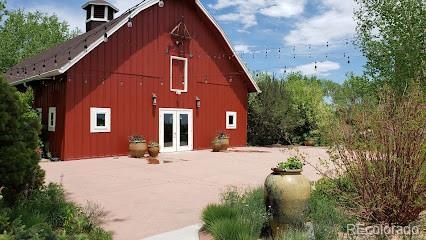 rear view of property featuring french doors, an outdoor structure, and a barn