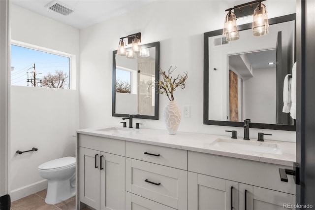535 Josephine St, Denver, CO 80206 - full bathroom with double vanity, toilet, tile patterned flooring, and baseboards