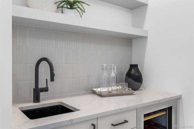 535 Josephine St, Denver, CO 80206 - detailed view of a sink, backsplash, white cabinetry, and light stone countertops