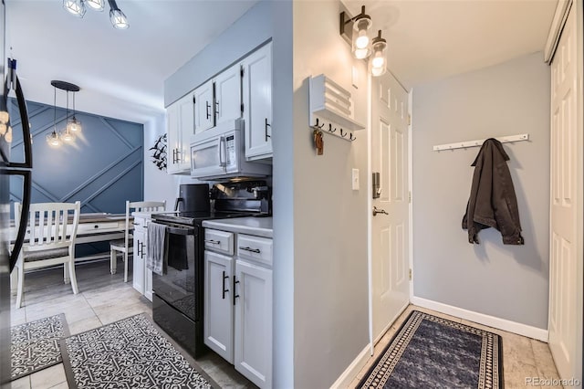 kitchen featuring electric range, pendant lighting, white cabinets, and light tile patterned floors