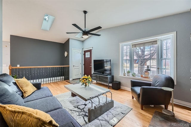 living area with baseboards, a ceiling fan, and wood finished floors