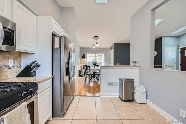 kitchen featuring light tile patterned floors, visible vents, white cabinets, appliances with stainless steel finishes, and tasteful backsplash