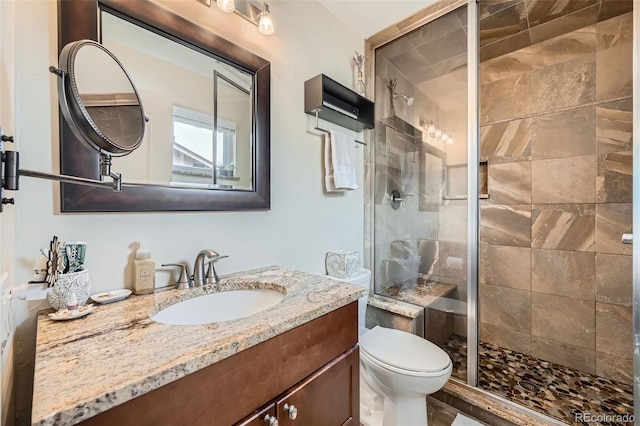 full bath with vanity, a shower stall, and toilet