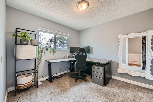 carpeted office space with a textured ceiling and baseboards