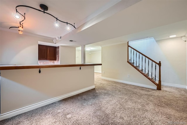 kitchen featuring baseboards, light carpet, and a kitchen breakfast bar