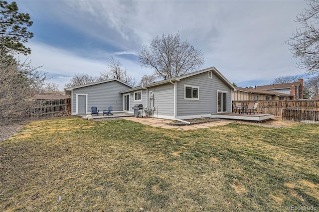 back of house featuring a yard, a patio, a wooden deck, and a fenced backyard