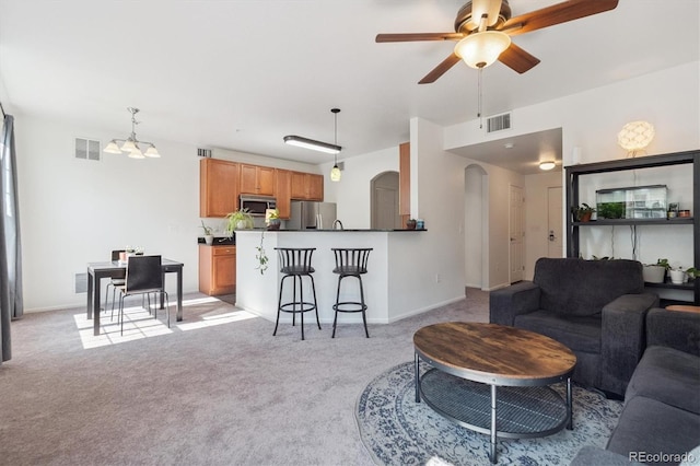 17388 Nature Walk Trl Unit 202, Parker, CO 80134 - living area with arched walkways, light carpet, ceiling fan, and a chandelier