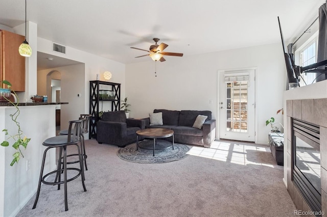 17388 Nature Walk Trl Unit 202, Parker, CO 80134 - living room with light colored carpet, a fireplace, and ceiling fan