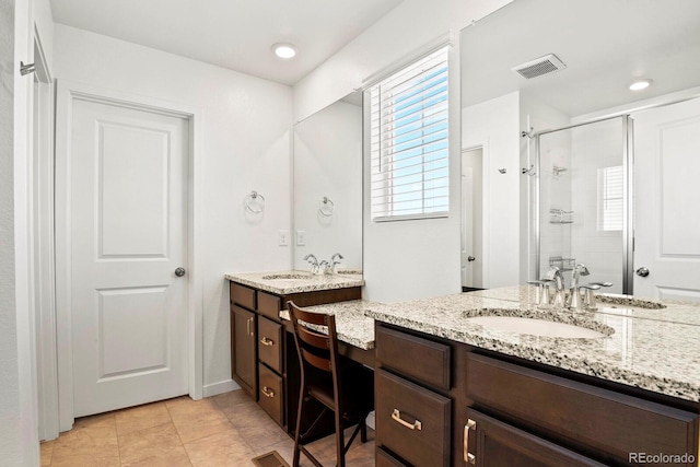 bathroom with tile patterned flooring, vanity, and walk in shower