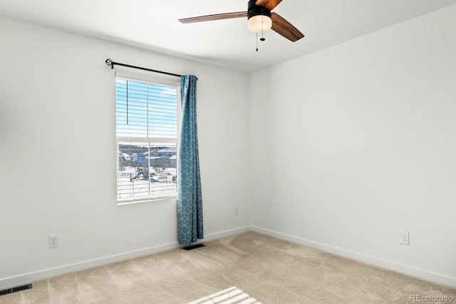 spare room featuring light colored carpet and ceiling fan