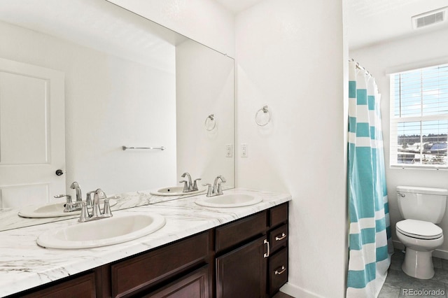 bathroom with tile patterned flooring, vanity, and toilet