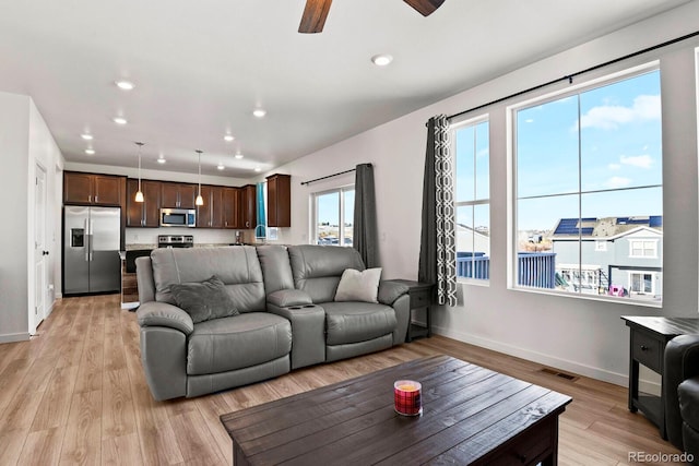 living room with light hardwood / wood-style floors and ceiling fan