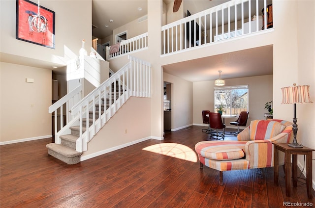 living room featuring a towering ceiling and hardwood / wood-style floors