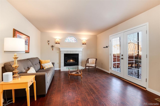 living room with dark hardwood / wood-style flooring, a tile fireplace, and french doors