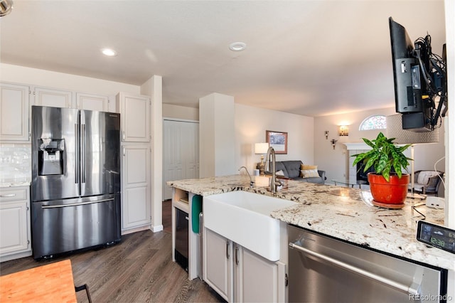 kitchen with sink, white cabinetry, light stone counters, dark hardwood / wood-style flooring, and stainless steel appliances