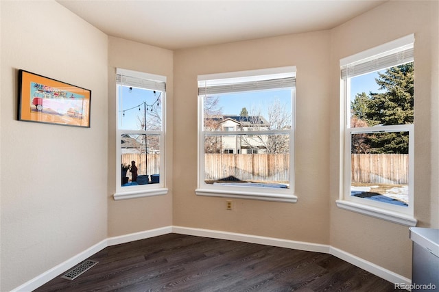 unfurnished dining area featuring dark wood-type flooring