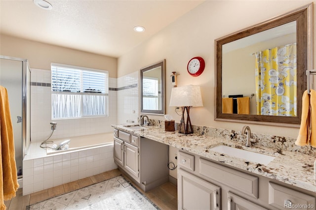 bathroom with hardwood / wood-style flooring, vanity, and separate shower and tub