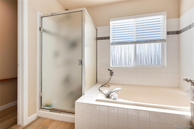 bathroom featuring plus walk in shower and hardwood / wood-style floors