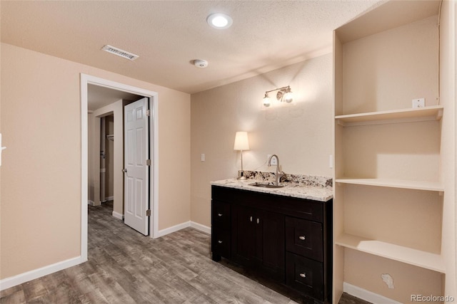 bathroom featuring sink, hardwood / wood-style floors, and a textured ceiling