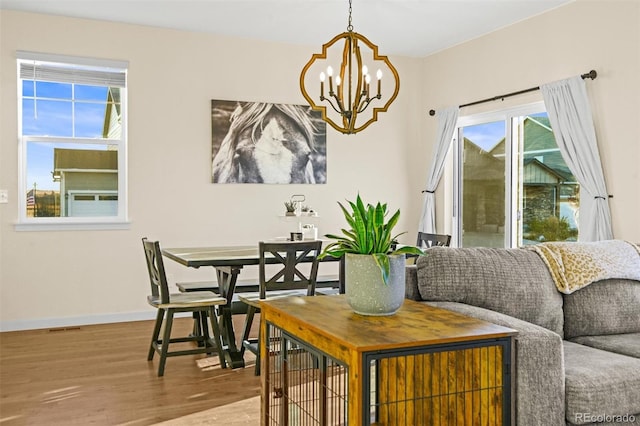 dining space with wood-type flooring and a chandelier