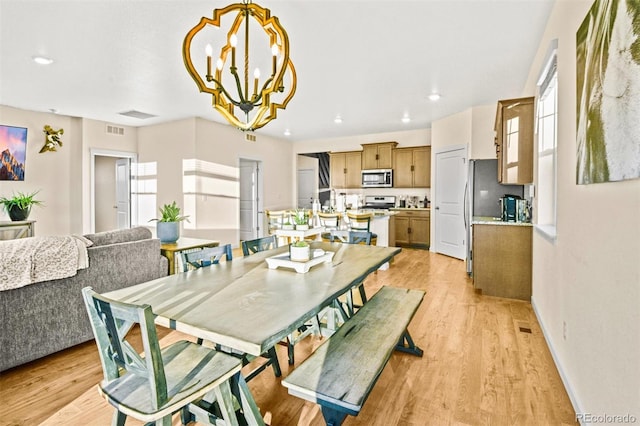 dining room featuring a notable chandelier and light hardwood / wood-style floors