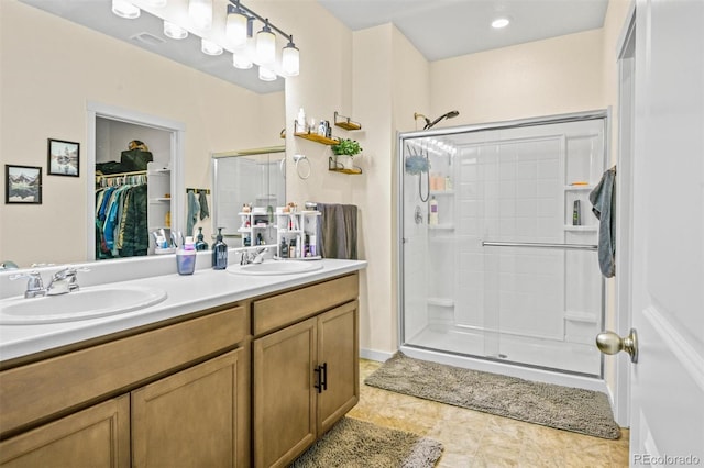 bathroom featuring a shower with door and vanity