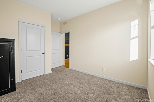 unfurnished bedroom with carpet flooring and multiple windows