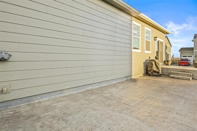 view of side of home with a patio area and a garage