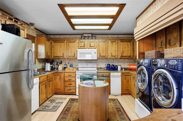 214 Poppy St, Golden, CO 80401 - kitchen featuring white appliances, washer and dryer, light wood finished floors, brown cabinetry, and a textured ceiling