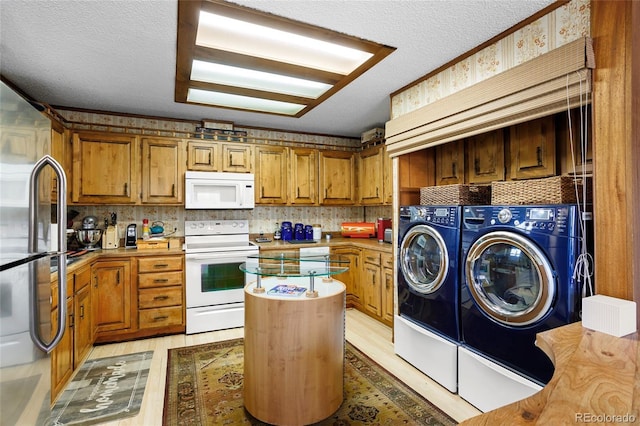 214 Poppy St, Golden, CO 80401 - kitchen featuring white appliances, independent washer and dryer, a textured ceiling, brown cabinetry, and light wood finished floors