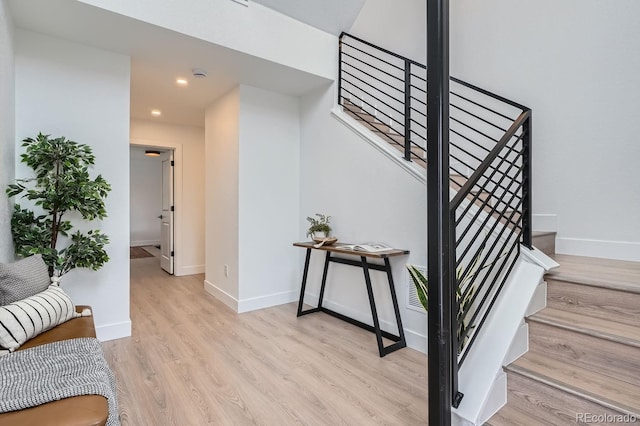 stairway with recessed lighting, wood finished floors, and baseboards