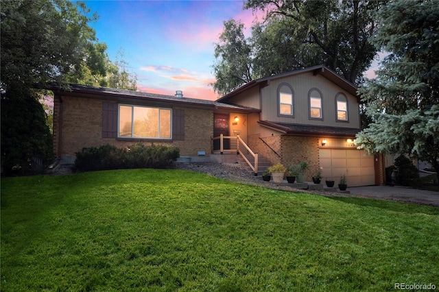 tri-level home with a garage and a lawn