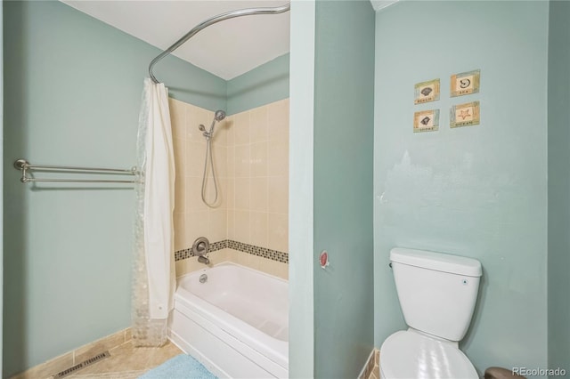 bathroom featuring toilet, shower / bath combo with shower curtain, and tile patterned flooring