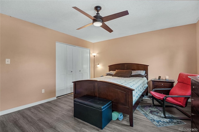 bedroom featuring a closet, ceiling fan, hardwood / wood-style flooring, and a textured ceiling