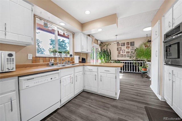 kitchen featuring white cabinetry, sink, and white appliances